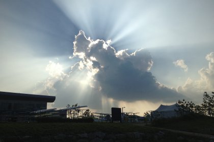 Photo of the sun is shining through the clouds above a building, WC Chungju, South Korea, August 2013, Reinder Nijhoff