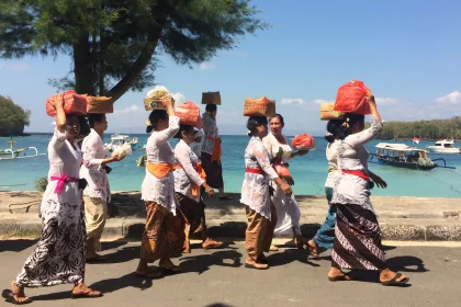 Photo of a group of people walking down a street next to a body of water, Indonesia, August 2014, Reinder Nijhoff