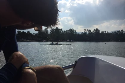 Photo of a man sitting on a boat in the water, Indonesia, August 2014, Reinder Nijhoff