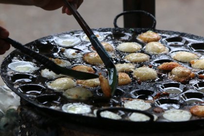 Photo of a person cooking food on a grill with tongs, Myanmar, India, Nepal, June 2015, Reinder Nijhoff