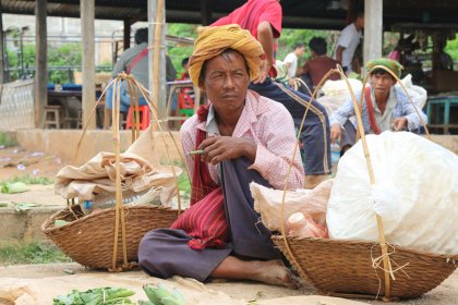 Photo of a woman sitting on the ground with baskets of vegetables, Myanmar, India, Nepal, June 2015, Reinder Nijhoff