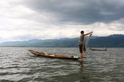 Photo of a man standing on a boat in the water, Myanmar, India, Nepal, June 2015, Reinder Nijhoff