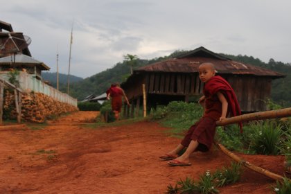 Photo of a man carrying a stick across a dirt road, Myanmar, India, Nepal, June 2015, Reinder Nijhoff