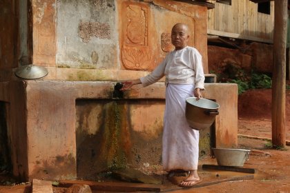 Photo of a man standing in front of a water fountain, Myanmar, India, Nepal, June 2015, Reinder Nijhoff