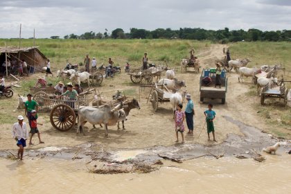 Photo of a group of people standing in a muddy field, Myanmar, India, Nepal, June 2015, Reinder Nijhoff