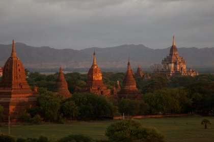 Photo of a group of temples in a field with mountains in the background, Myanmar, India, Nepal, June 2015, Reinder Nijhoff