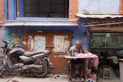 Photo of a man sitting at a table next to a motorcycle, Myanmar, India, Nepal, June 2015, Reinder Nijhoff