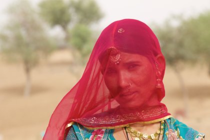 Photo of a woman with a red veil on her head, Myanmar, India, Nepal, June 2015, Reinder Nijhoff