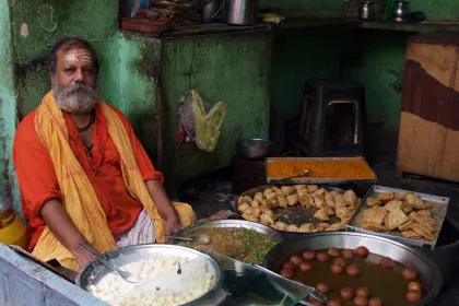 Photo of a man sitting in front of a table full of food, Myanmar, India, Nepal, June 2015, Reinder Nijhoff