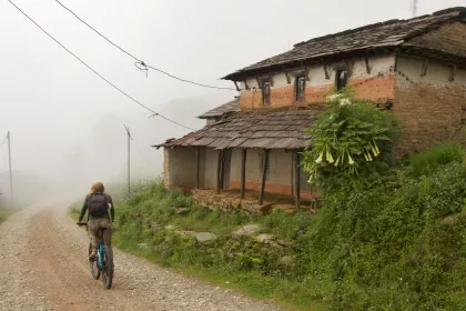 Photo of a person riding a bike down a dirt road, Myanmar, India, Nepal, June 2015, Reinder Nijhoff