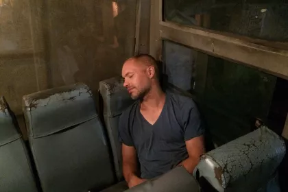 Photo of a man sitting on a bench in a room, Myanmar, India, Nepal, June 2015, Reinder Nijhoff