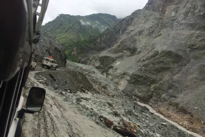 Photo of a truck driving down a dirt road next to a mountain, Myanmar, India, Nepal, June 2015, Reinder Nijhoff