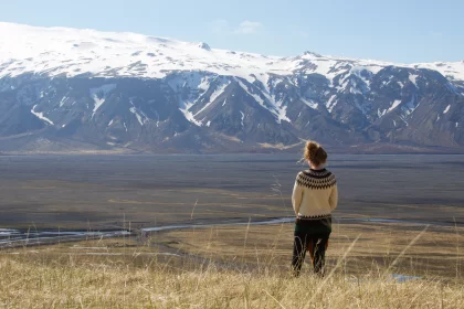 Photo of a woman standing on top of a grass covered field, Iceland, May 2016, Reinder Nijhoff
