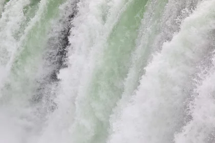 Photo of a man riding a surfboard on top of a waterfall, Iceland, June 2016, Reinder Nijhoff