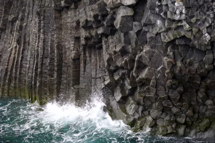 Photo of a large rock formation next to a body of water, Iceland, June 2016, Reinder Nijhoff