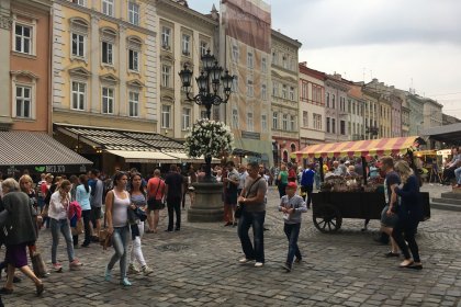 Photo of a crowd of people walking around a street next to tall buildings, Lviv, Ukraine, September 2016, Reinder Nijhoff
