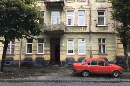 Photo of a red car parked in front of a building, Lviv, Ukraine, September 2016, Reinder Nijhoff