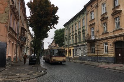 Photo of a bus driving down a street next to tall buildings, Lviv, Ukraine, September 2016, Reinder Nijhoff