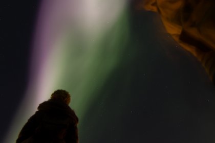 Photo of a man standing in front of a green and purple aurora bore, Northern Lights, October 2016, Reinder Nijhoff