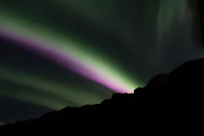 Photo of a person standing in front of a green and purple light, Northern Lights, October 2016, Reinder Nijhoff