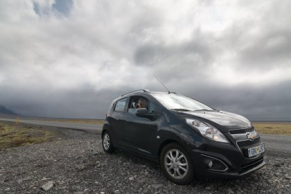 Photo of a small black car parked on the side of a road, Iceland, May 2017, Reinder Nijhoff