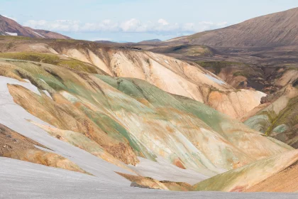 Photo of a man riding a snowboard on top of a snow covered slope, Landmannalaugar &rarr; Skogafoss, August 2017, Reinder Nijhoff