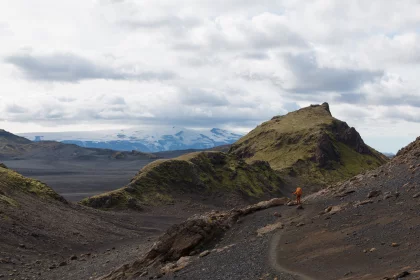 Photo of a person walking up a hill with mountains in the background, Landmannalaugar &rarr; Skogafoss, August 2017, Reinder Nijhoff