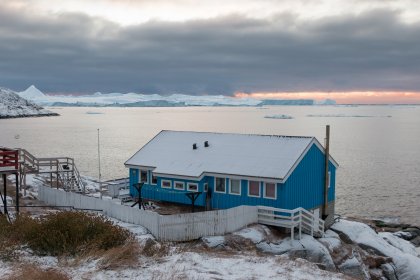 Photo of a small blue house sitting on top of a snow covered hill, Greenland, October 2017, Reinder Nijhoff