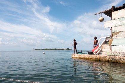 Photo of a couple of men standing on top of a boat, Santa Cruz del Islote, Colombia, December 2017, Reinder Nijhoff