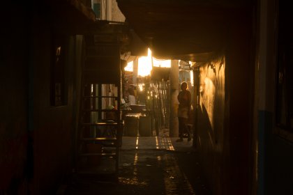 Photo of a person walking down a dark alley way, Santa Cruz del Islote, Colombia, December 2017, Reinder Nijhoff