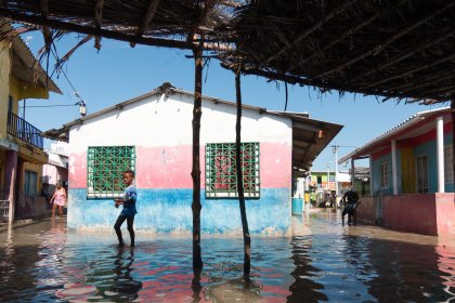 Photo of a man standing in a flooded street next to a building, Santa Cruz del Islote, Colombia, December 2017, Reinder Nijhoff