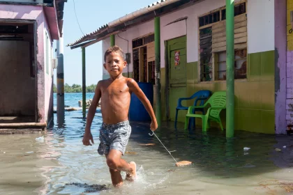 Photo of a young boy walking through a flooded street, Santa Cruz del Islote, Colombia, December 2017, Reinder Nijhoff