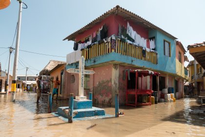 Photo of a house in a flooded street with people standing around, Santa Cruz del Islote, Colombia, December 2017, Reinder Nijhoff