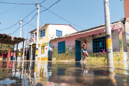 Photo of a man standing in a flooded street in front of a house, Santa Cruz del Islote, Colombia, December 2017, Reinder Nijhoff