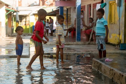 Photo of a group of children playing in a puddle of water, Santa Cruz del Islote, Colombia, December 2017, Reinder Nijhoff