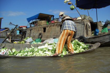Photo of a man standing in a boat filled with lettuce, Thailand, Laos, Cambodja & Vietnam, November 2005, Reinder Nijhoff