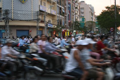 Photo of a large group of people riding motorcycles down a street, Thailand, Laos, Cambodja & Vietnam, November 2005, Reinder Nijhoff