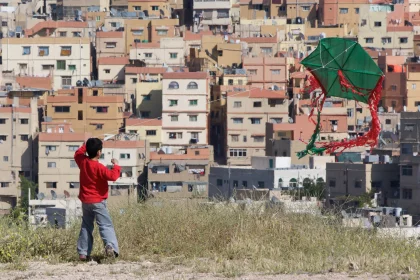 Photo of a young boy flying a kite in a city, Jordan, Syria, Lebanon, May 2009, Reinder Nijhoff